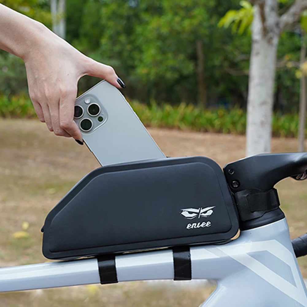 Phone being placed into a black phone holder attached to a bicycle handlebar with a blurred outdoor background.
