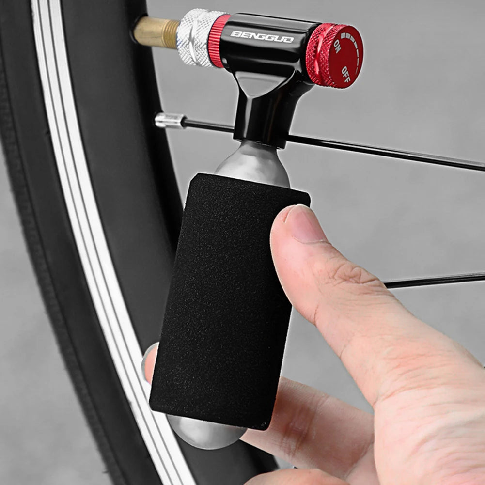 Hand using a tire inflator to inflate a car tire