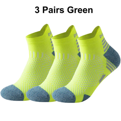 Three pairs of green running socks with blue toes on a white background