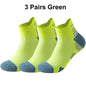 Three pairs of green running socks with blue toes on a white background