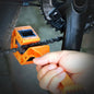 Person using an orange chain tool on a bicycle chain