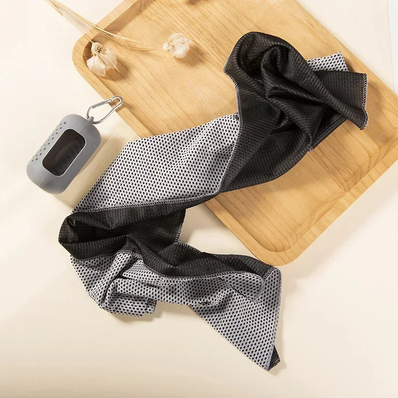 Black and gray patterned towel on a wooden tray with a small gray device.