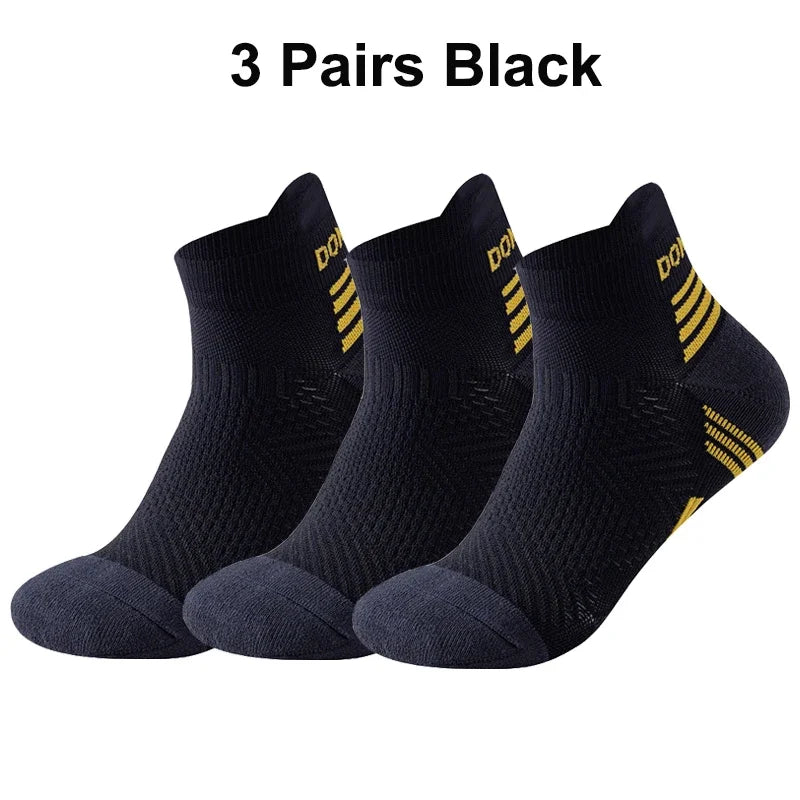 Three pairs of black running socks with yellow stripes on a white background