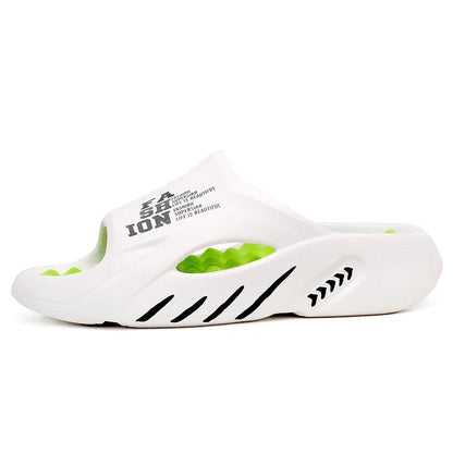 White slide sandal with green accents and branding on a white background