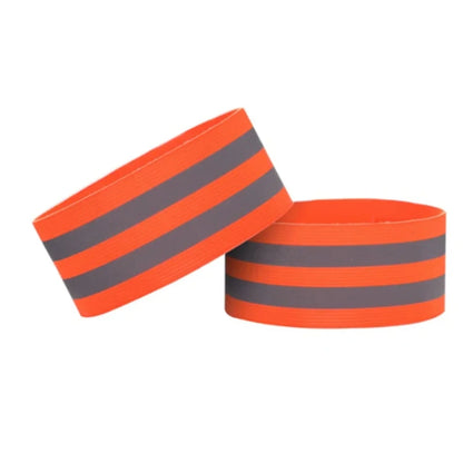 Two orange reflective wristbands with gray stripes on a white background