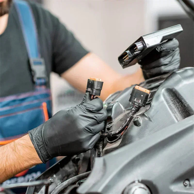 Person working on a vehicle engine with tools