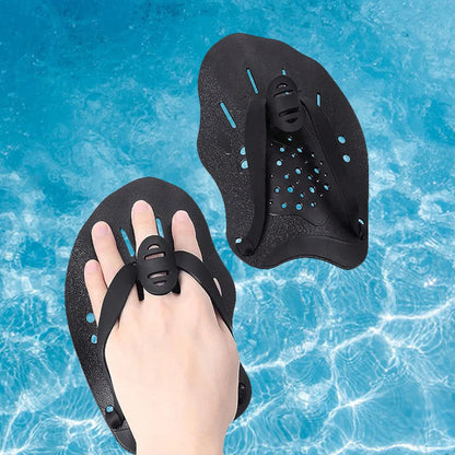 Black swim paddles on a hand with a blue water background