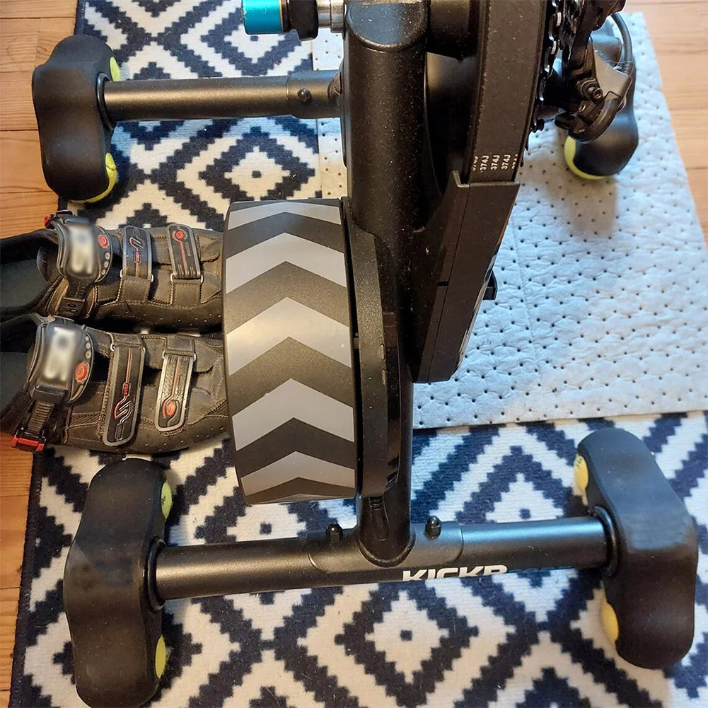Black exercise bike trainer on a patterned rug