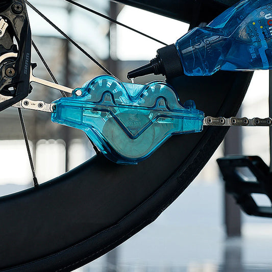 Blue chain tool attached to a bicycle chain with blurred background