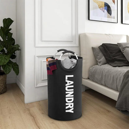 Black laundry basket with 'LAUNDRY' text in a bedroom setting.