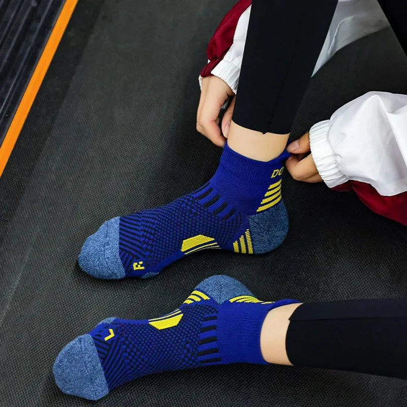 Person wearing blue running  socks with yellow accents on a dark surface