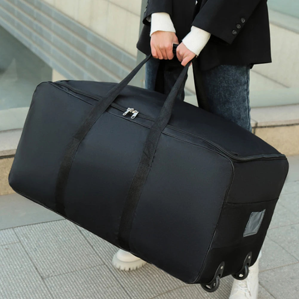 Person holding a large black travel bag outdoors.