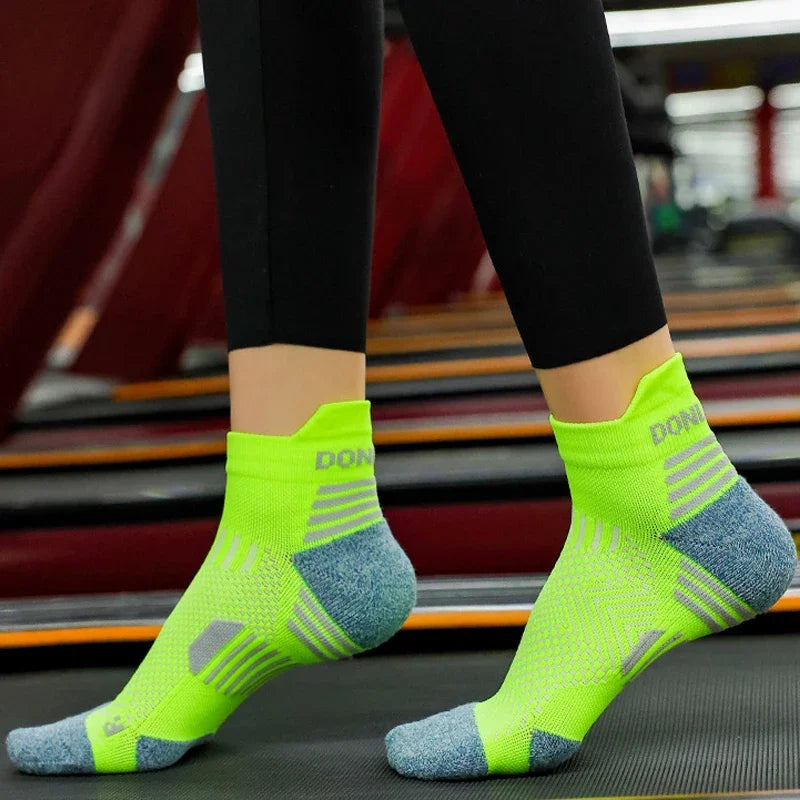 Person wearing bright running green socks with blue toes and heels on a blurred background