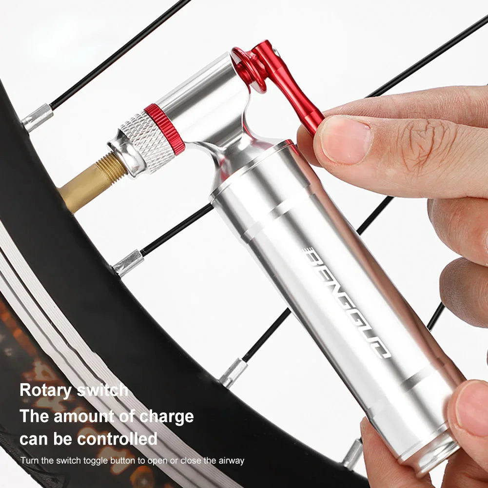 Bicycle pump being used on a bike tire with a hand holding it.