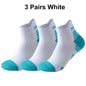 Three pairs of white running socks with teal accents on a white background